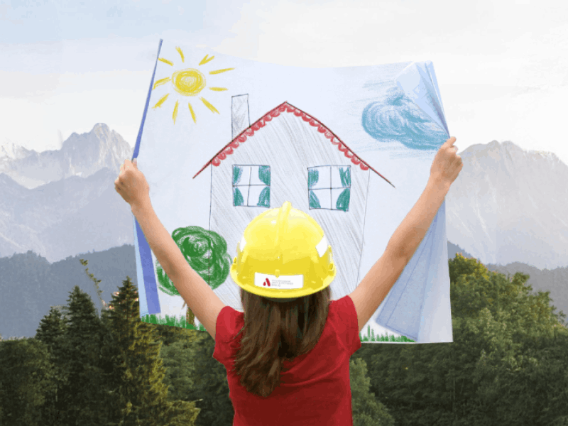 Kind mit Zeichnung von Haus vor schöner Landschaft mit Bergen im Hintergrund